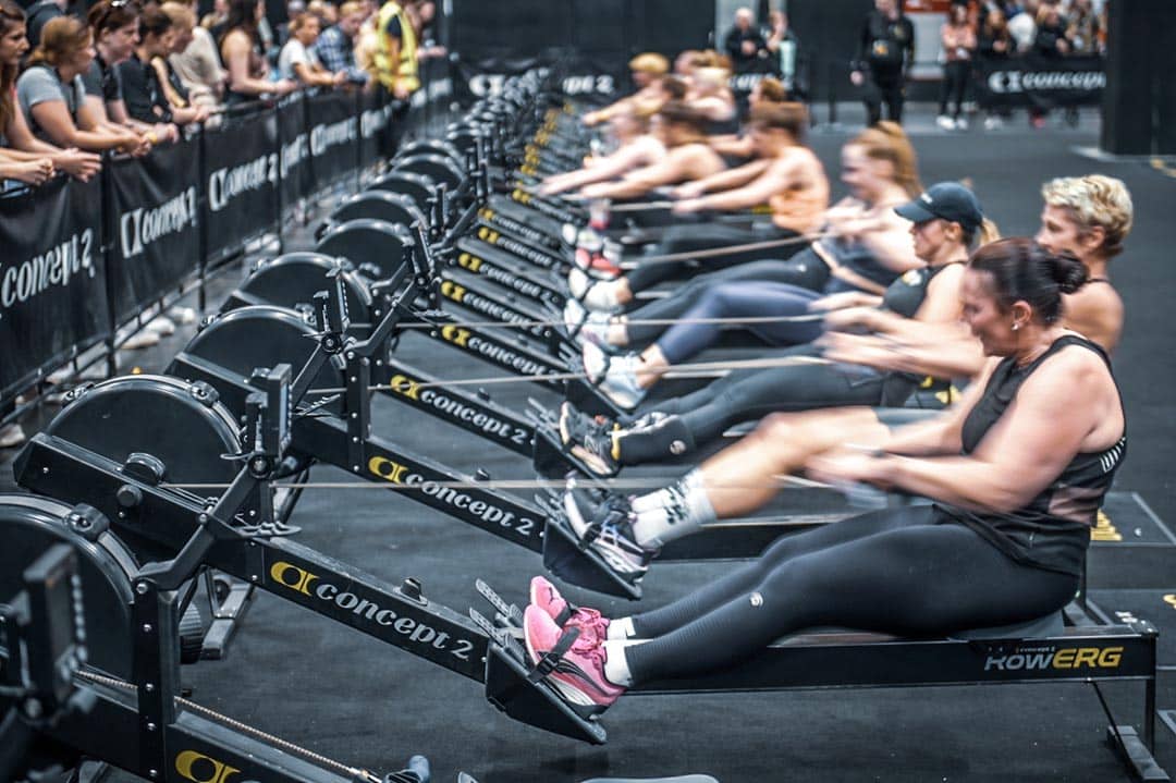 Groupe d’athlètes en action sur rameur RowERG à Hyrox Annecy