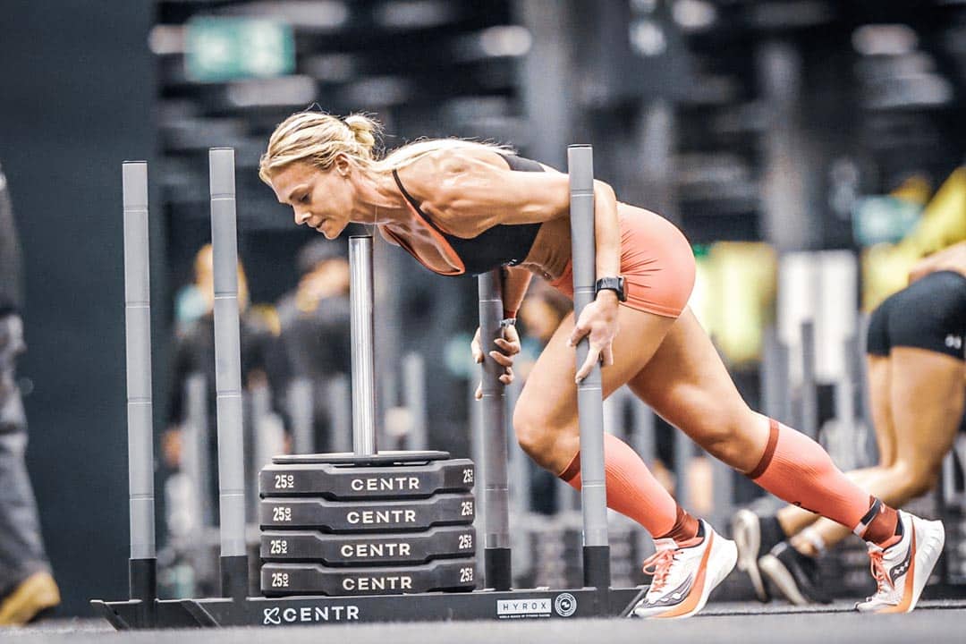 Athlète féminine poussant le traîneau Sled Push lors du Hyrox Annecy